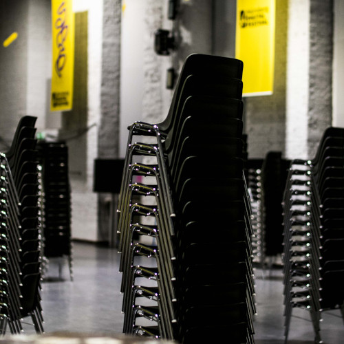 leere aufgestapelte Stühle, imHintergrund Nürnberg Digital Festival Poster