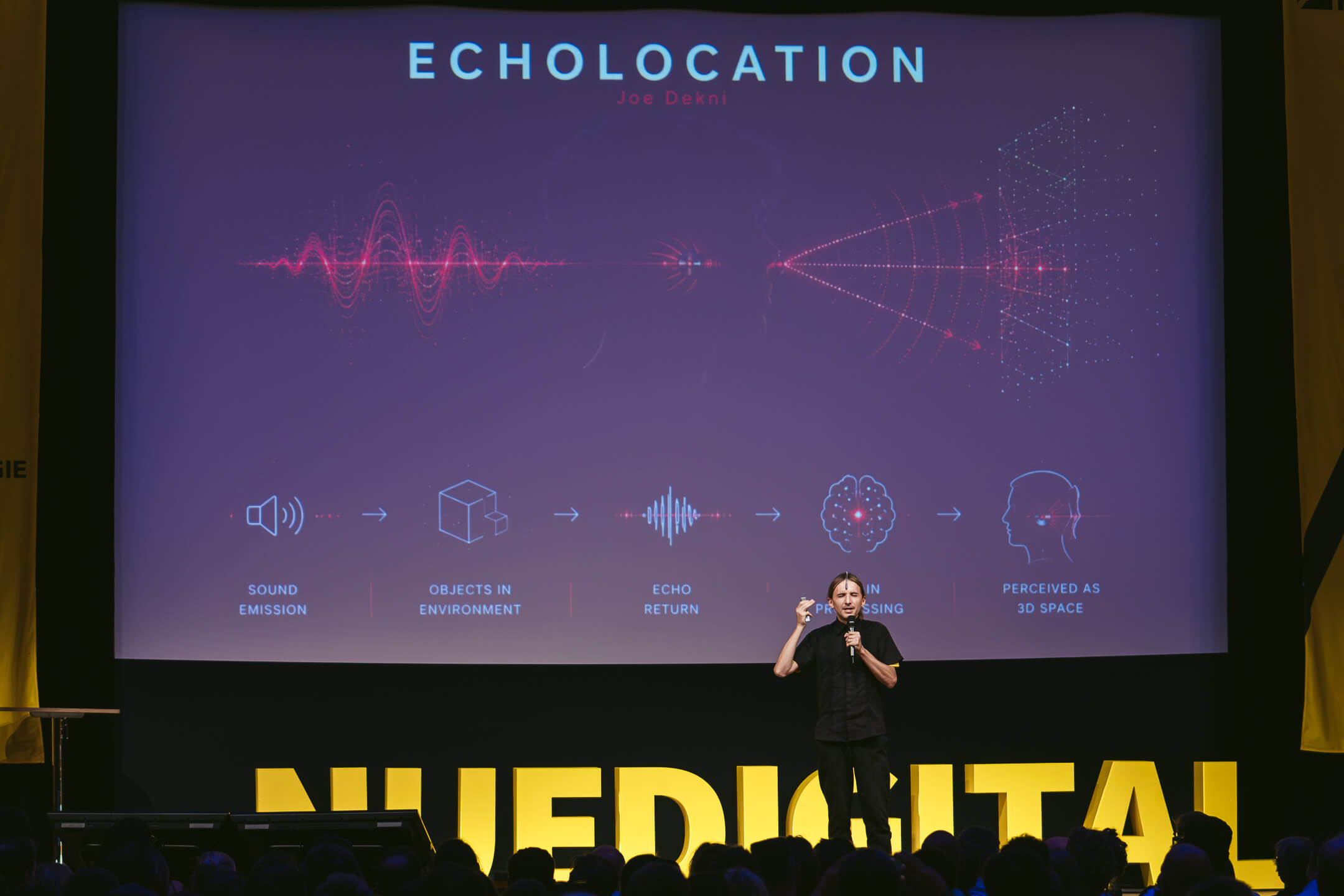 Sprecher vor Präsentation „Echolocation“ mit Schallwellen-Grafik und NUEDIGITAL-Schriftzug